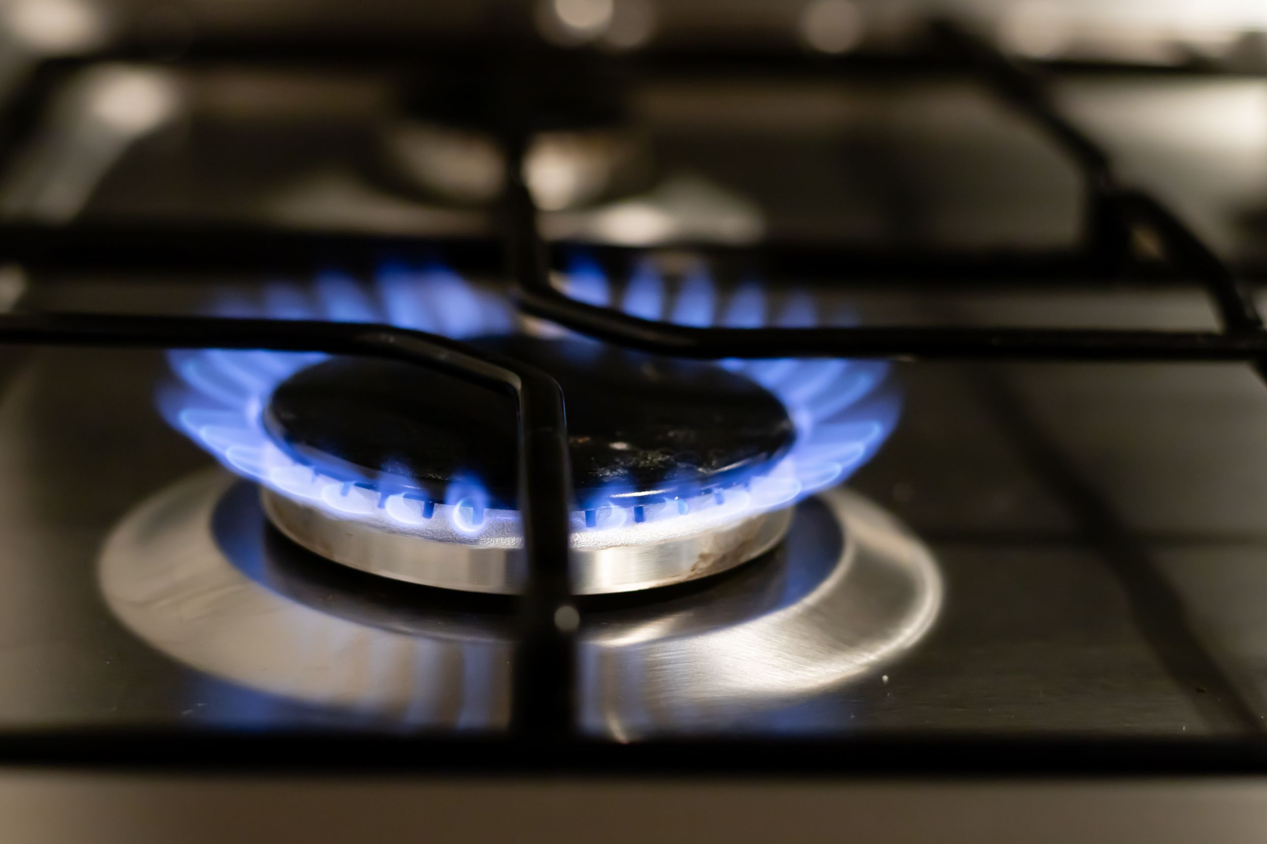 A detailed view of a blue flame on a stove, showcasing energy and heat