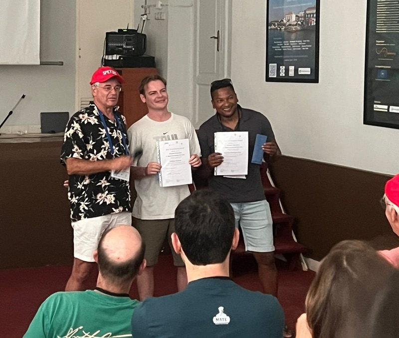 William Weston holding a certificate and standing between two other men.