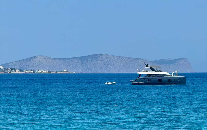 Sea with a boat and mountains at the back.