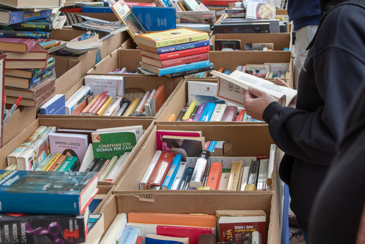 a person flicking through a book in a flea market