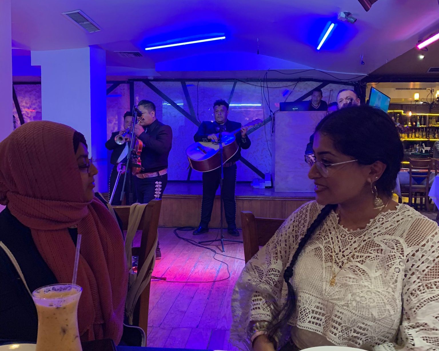 Image of two women looking at a mariachi band.