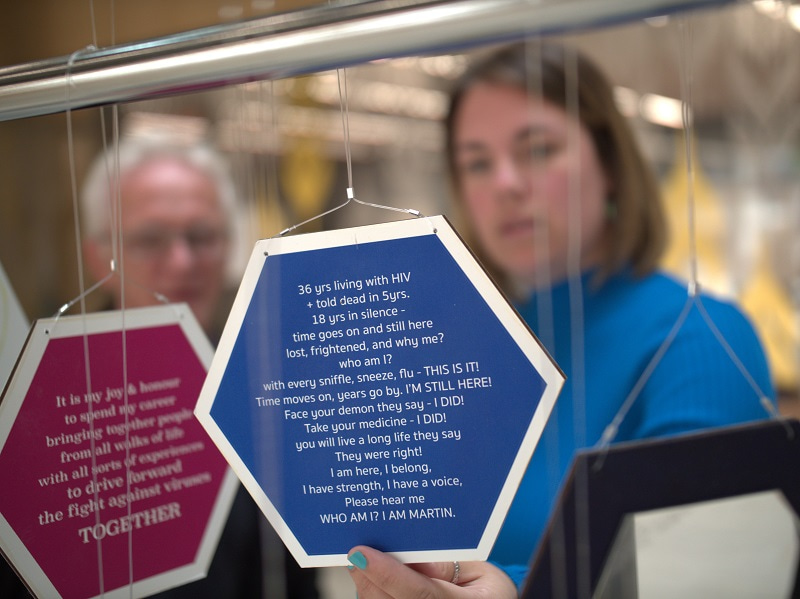 Photo of a  woman holding a card with a message from one of the Terrence Higgins Trust service users.