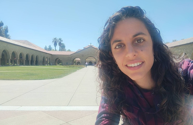 Selfie photo of Cristina Cadenas-Sanchez with the Stanford Memorial Church at Stanford University in the background.