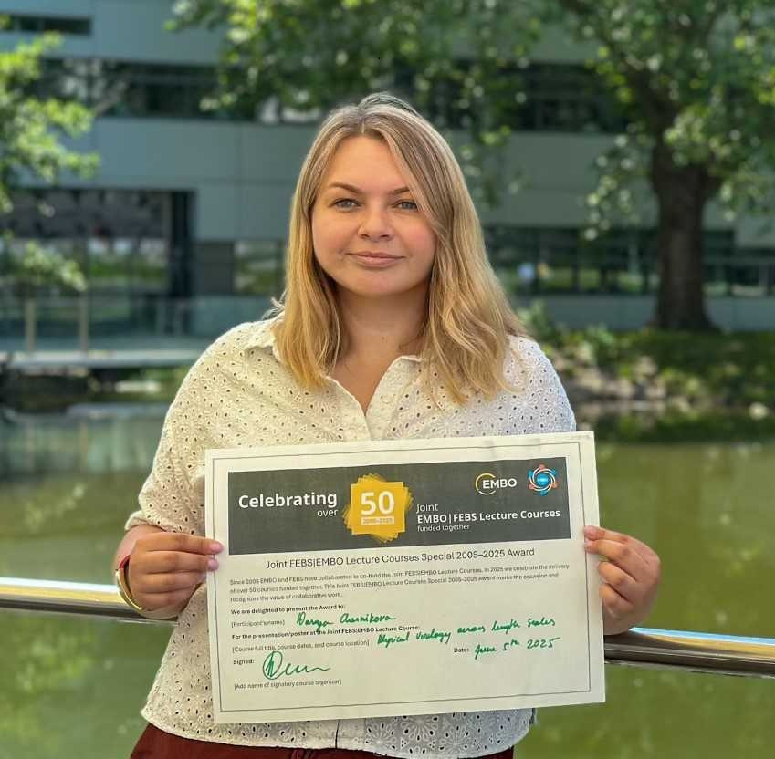 Darya holding a certificate and facing the camera.