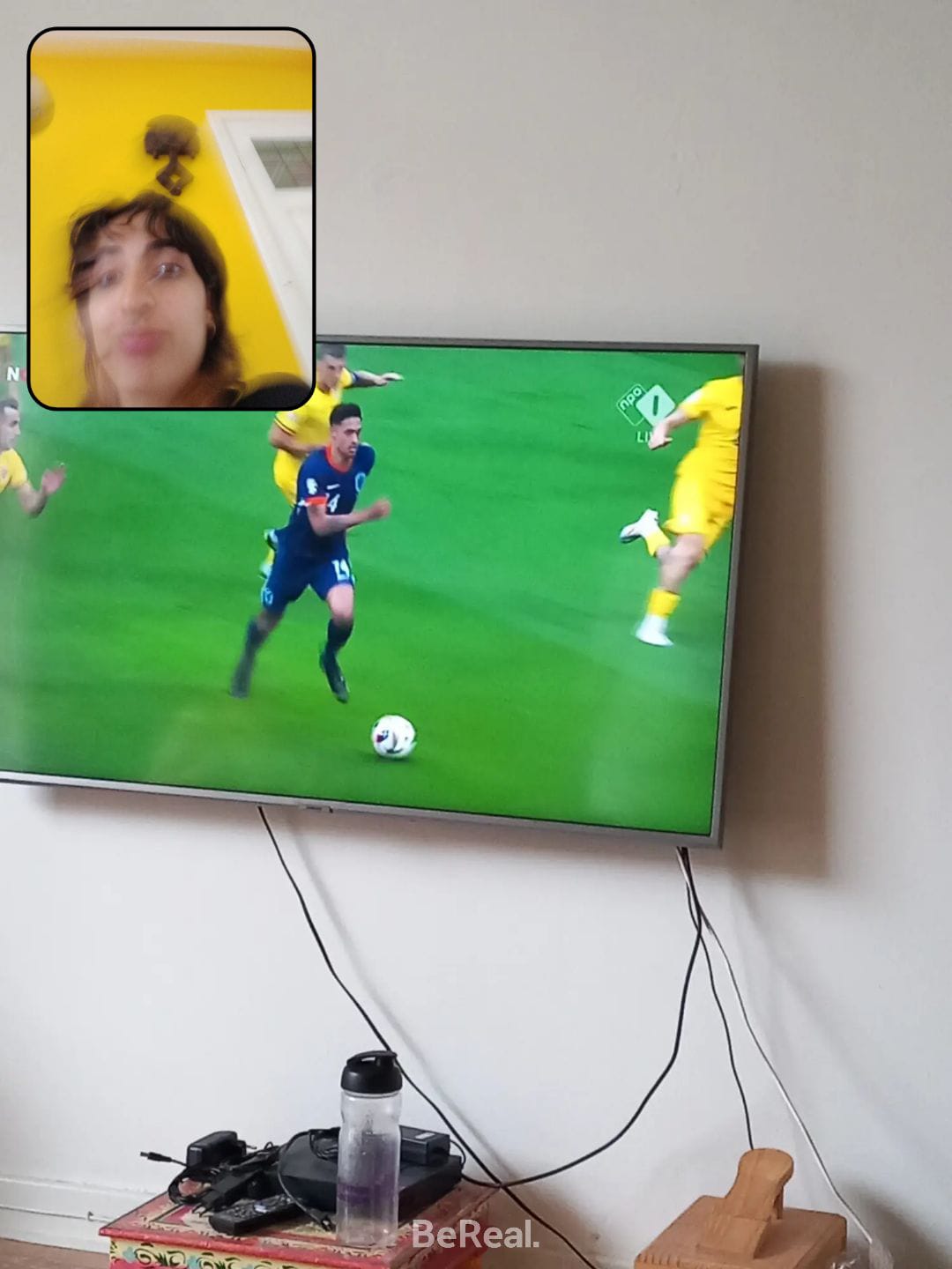 A picture of a television showing a footballer running on a green pitch 