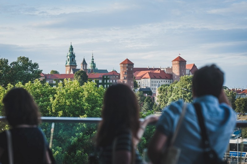 Photo showing the backs of people looking at the Wawel Castle from the ICE Congress Centre.