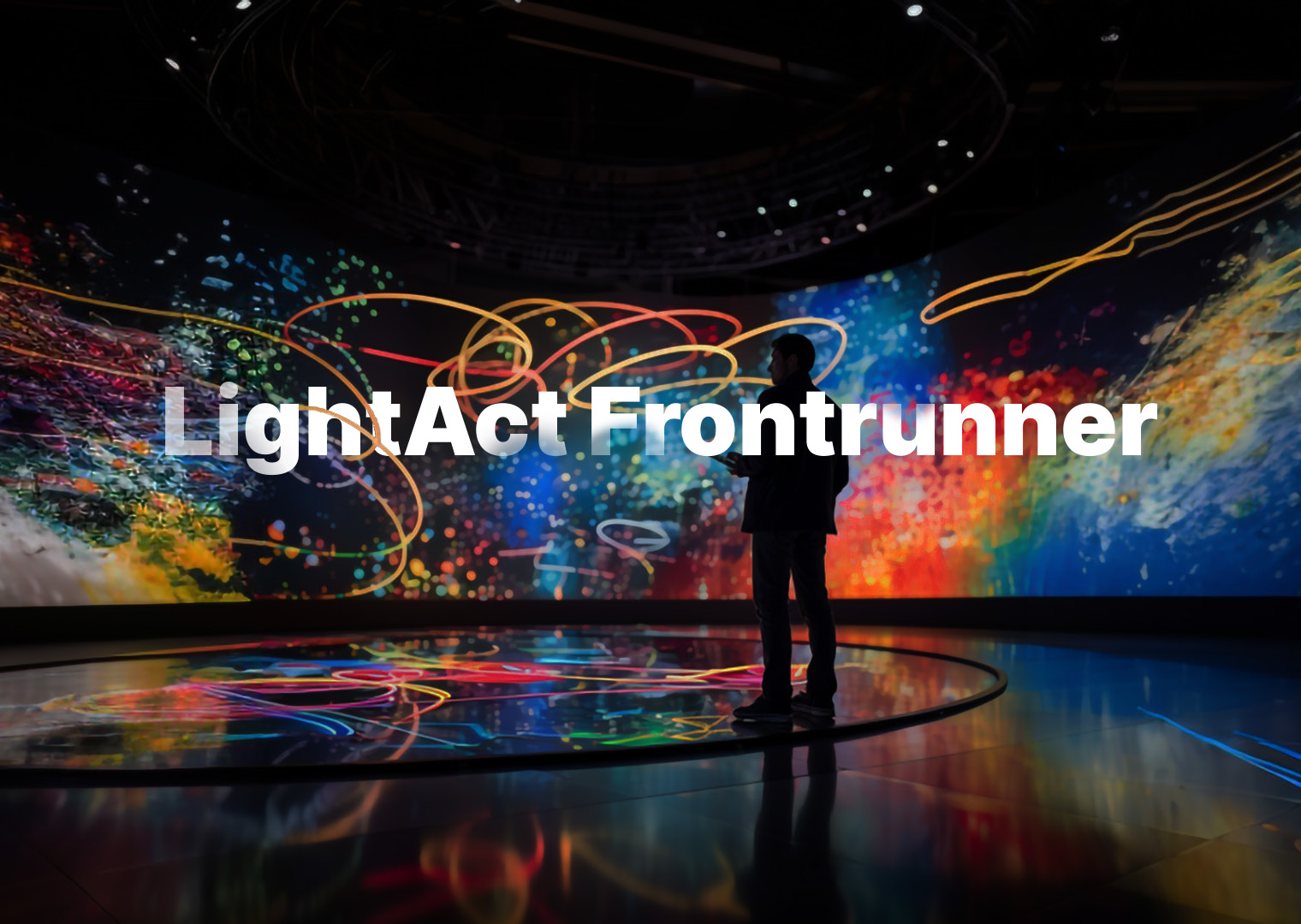 A man in front of colorful videoscreen with title LightAct Frontrunner in the middle