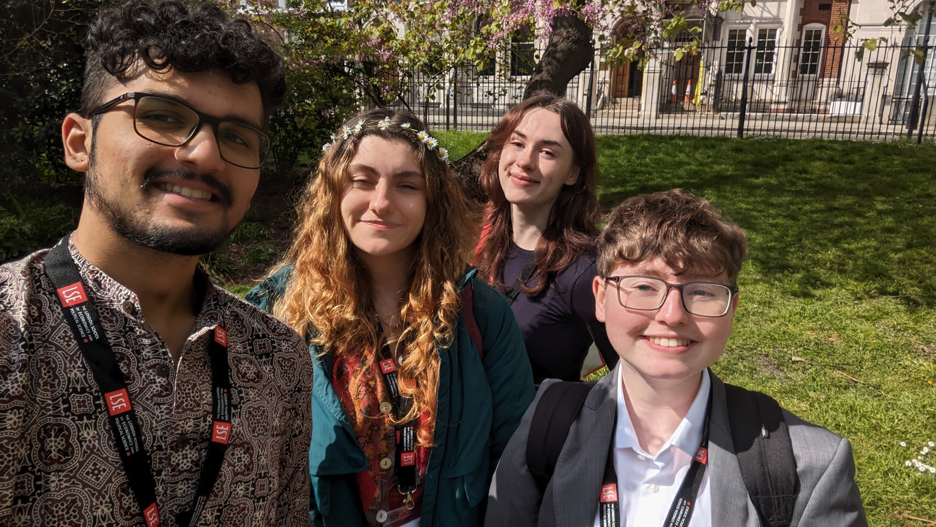 Myself, Sebastian, and my three fellow scholars from left to right: Vaibhav, Amarni and Lily. We are in a park, the sun is bright and there are cherry blossoms in the background.