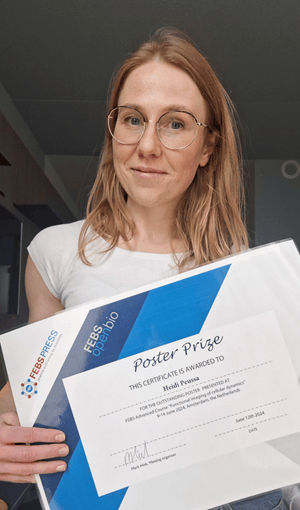 Photo of Heidi Peussa holding an award certificate.