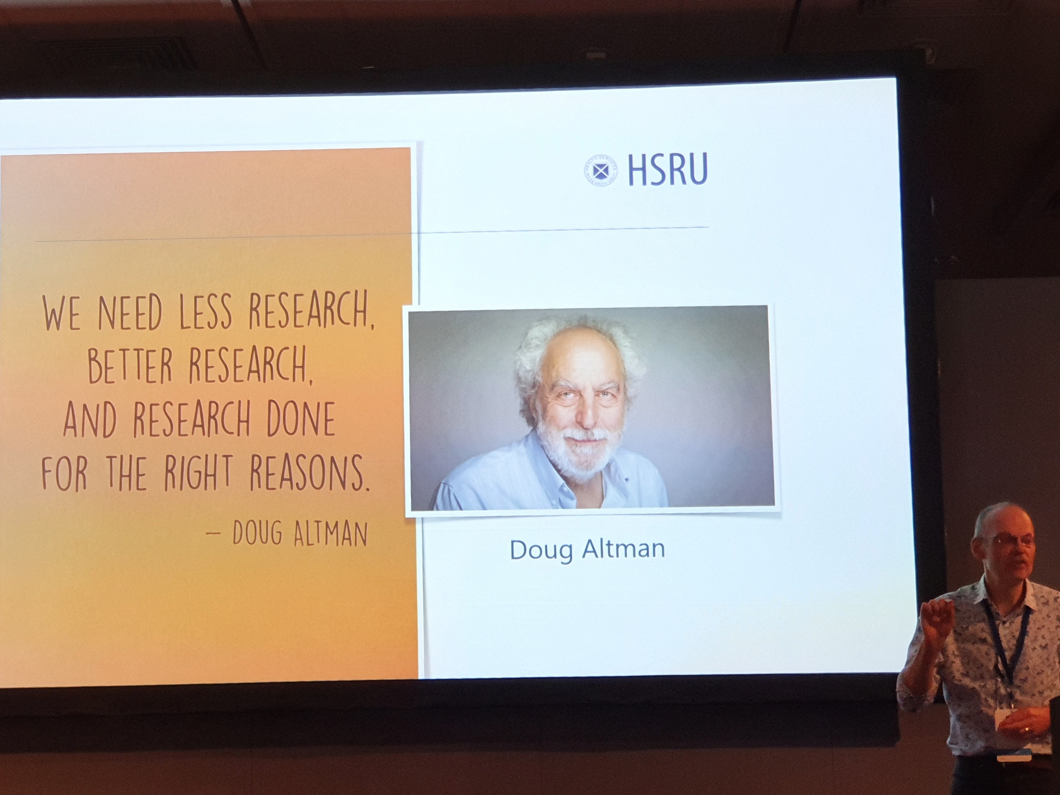 Shaun Treweek speaking in front of a quote from Doug Altman "We need less research, better research and research done for the right reasons".