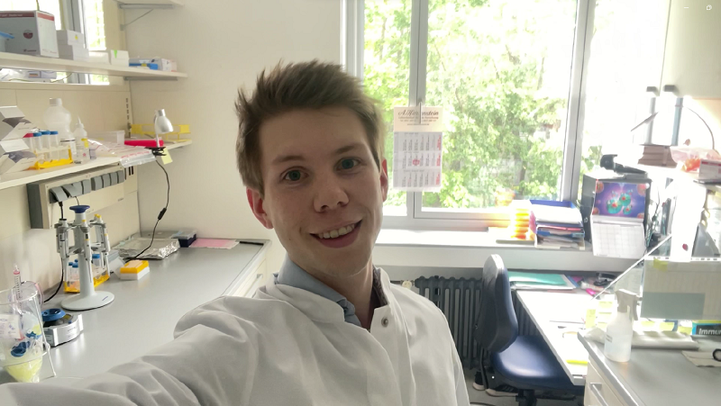 Photo of Patrick Penndorf in the laboratory, looking at the camera smiling and with the lab bench behind him.