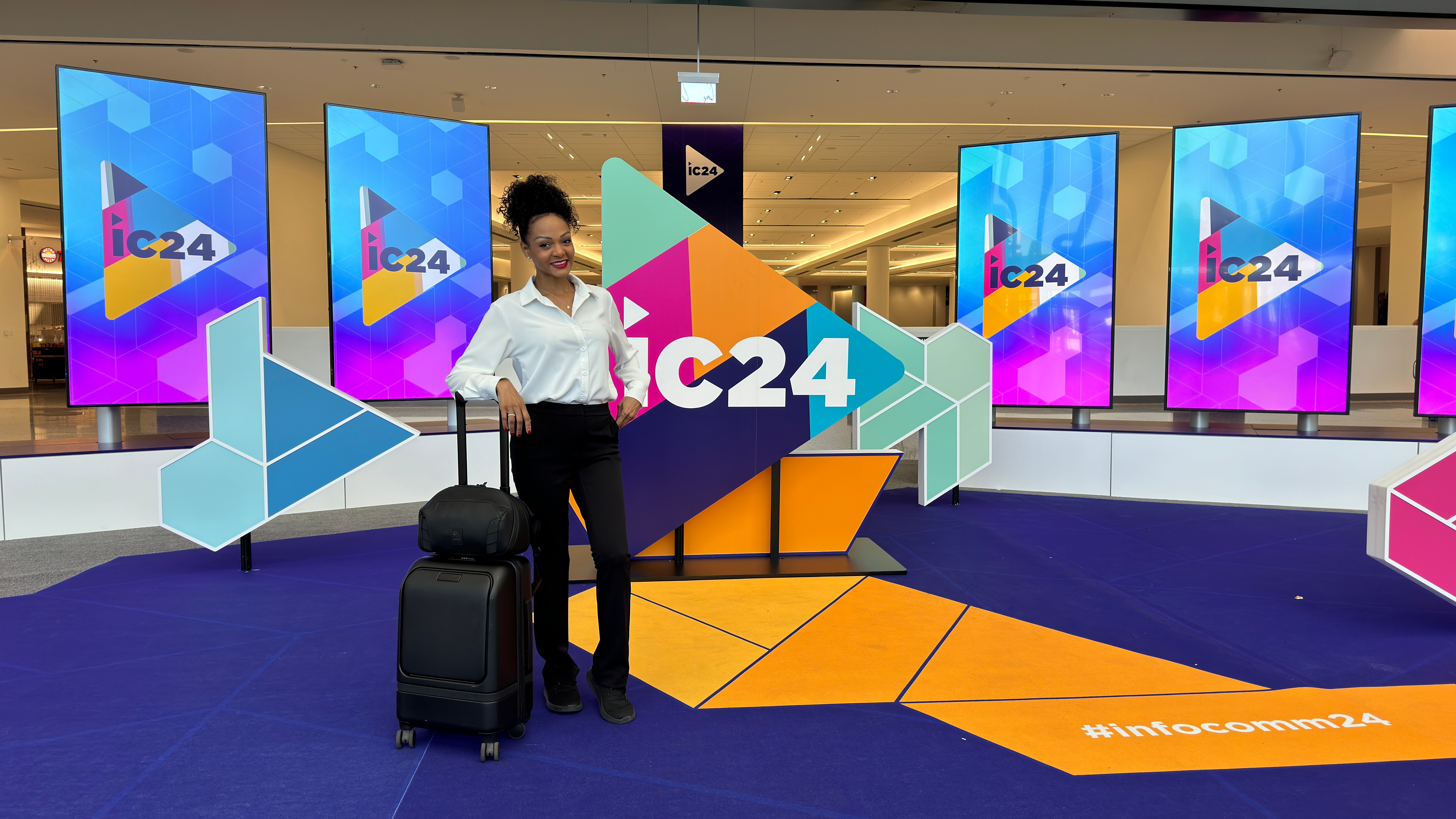 Posing in front of main InfoComm 2024 sign