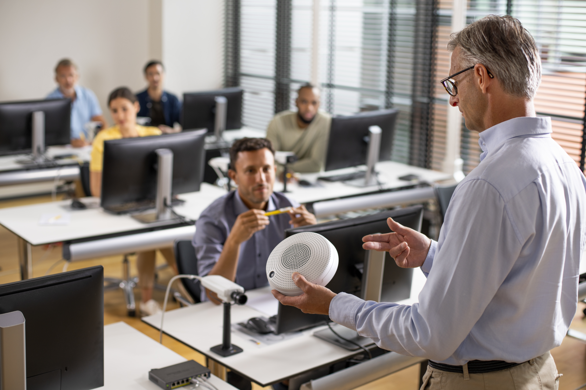 Trainer in front of class with network speaker and camera