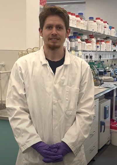 Photo of Alexander Röntgen in the laboratory, facing the camera, with the lab bench behind him.