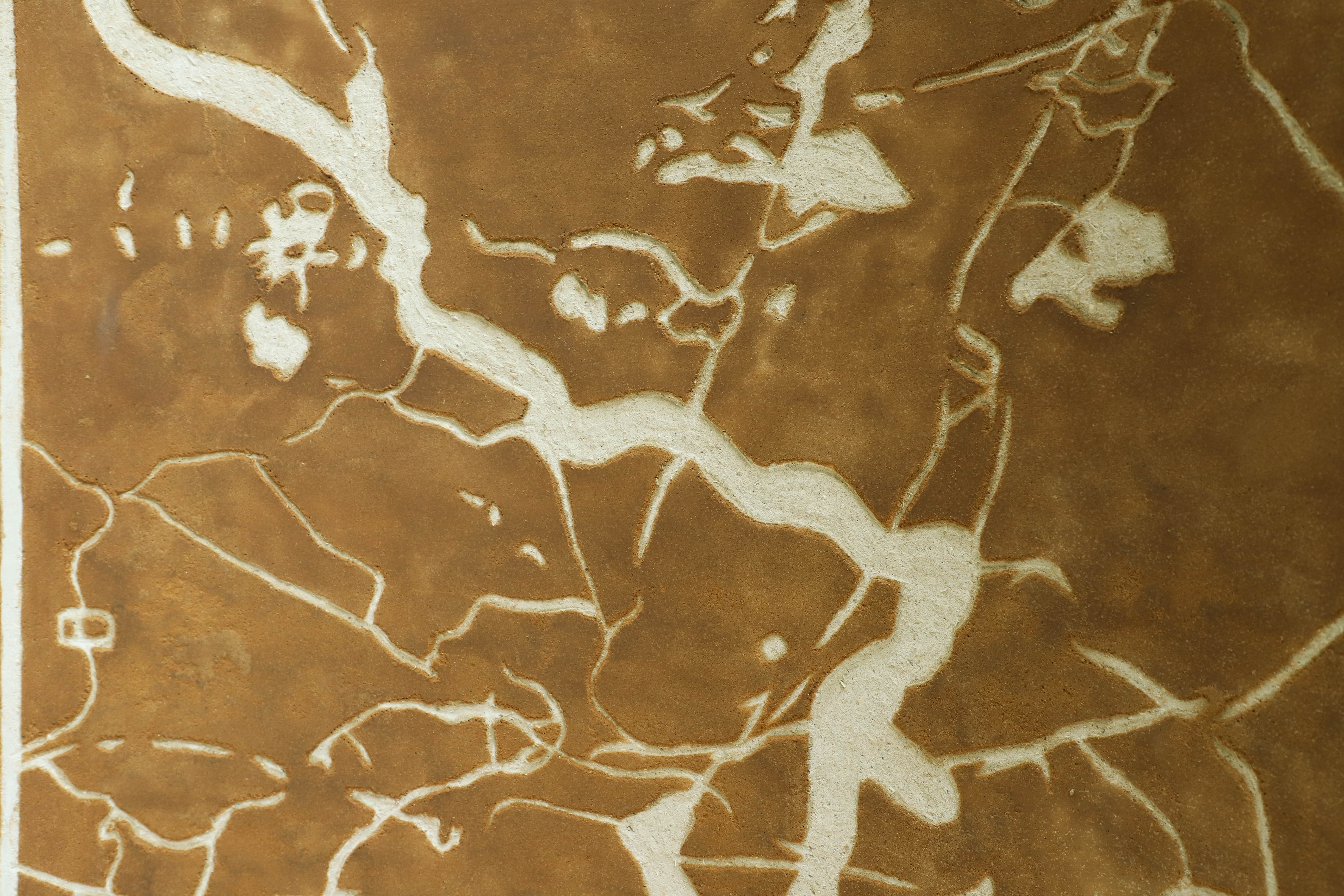 An close angle of the sgraffito designs that look like roots or a map.
