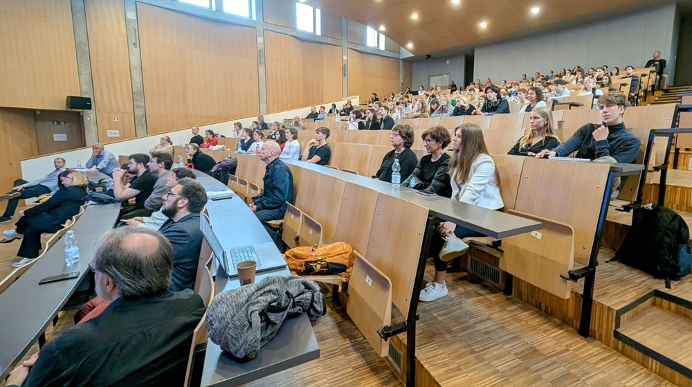 Photo of a conference venue with participants looking towards the stage.