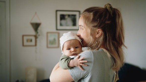 Woman holding a baby in her arms.
