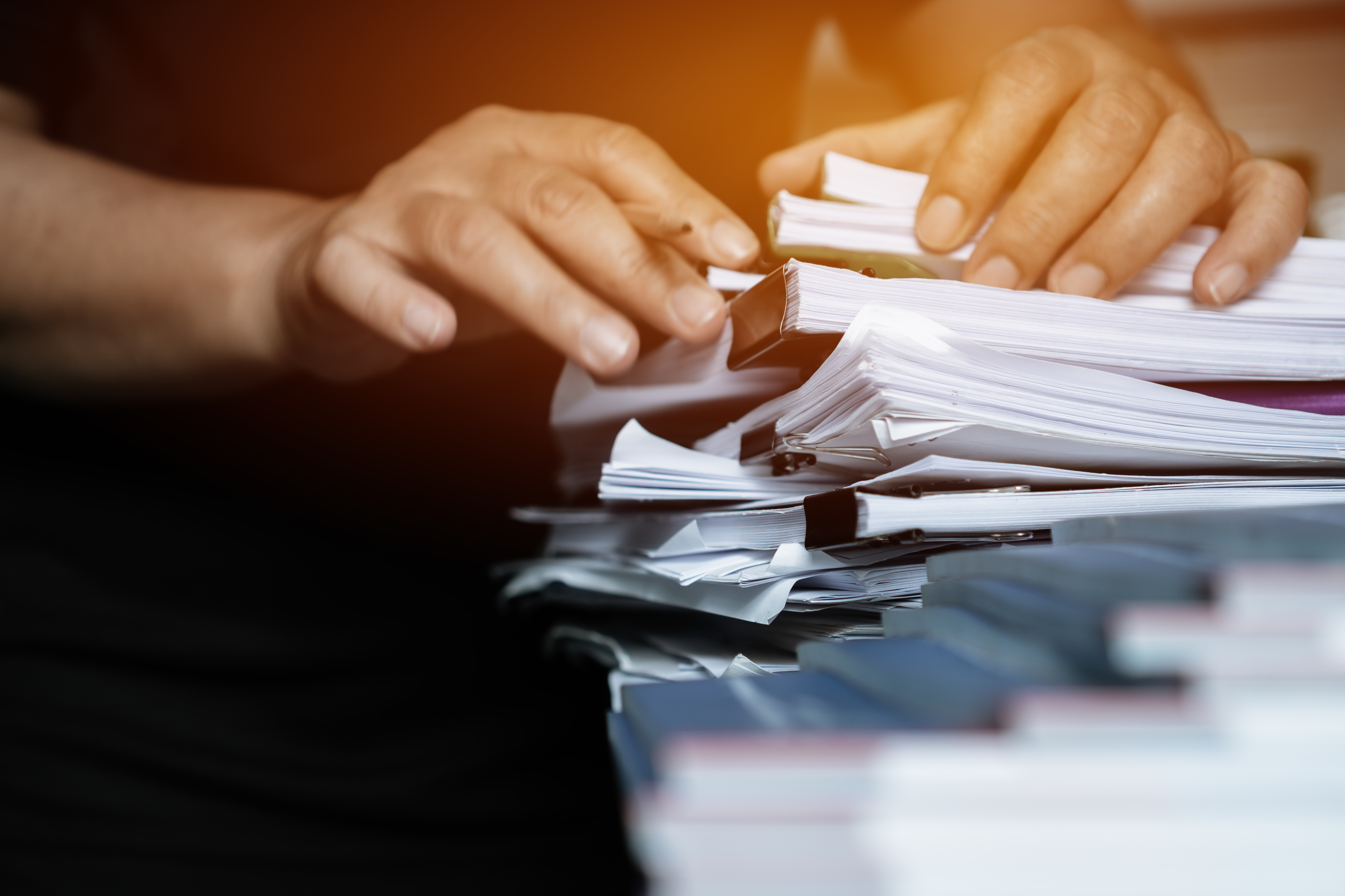 Image of someone searching through a pile of documents