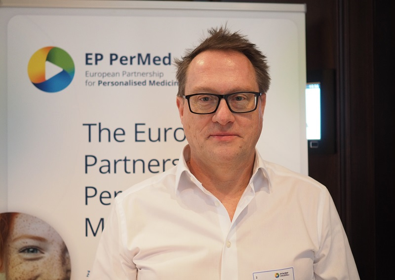 Photo of Dr Wolfgang Ballensiefen in front of an EP PerMed banner, smiling and facing the camera.