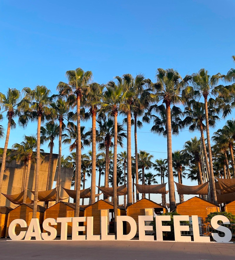 Palm trees with Castelldefels in large letters in front.