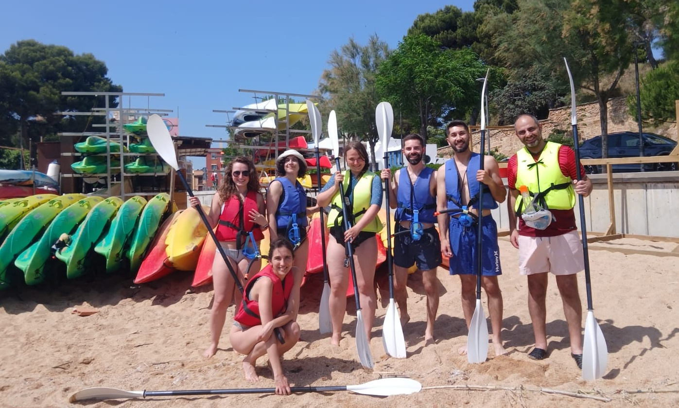 Group photo on the beach of young people with kayaking gear.