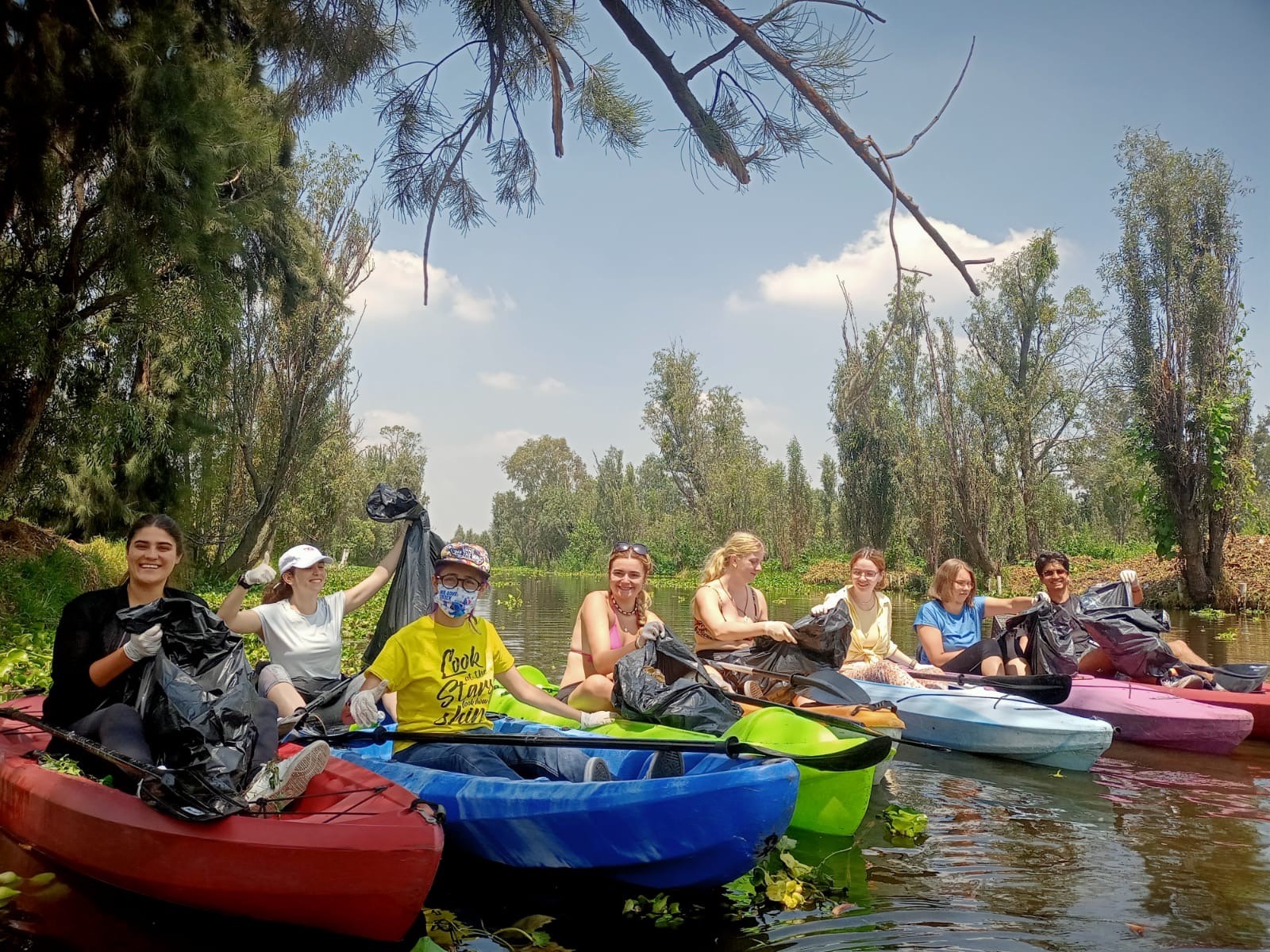 A group of people in kayaks on a river

Description automatically generated