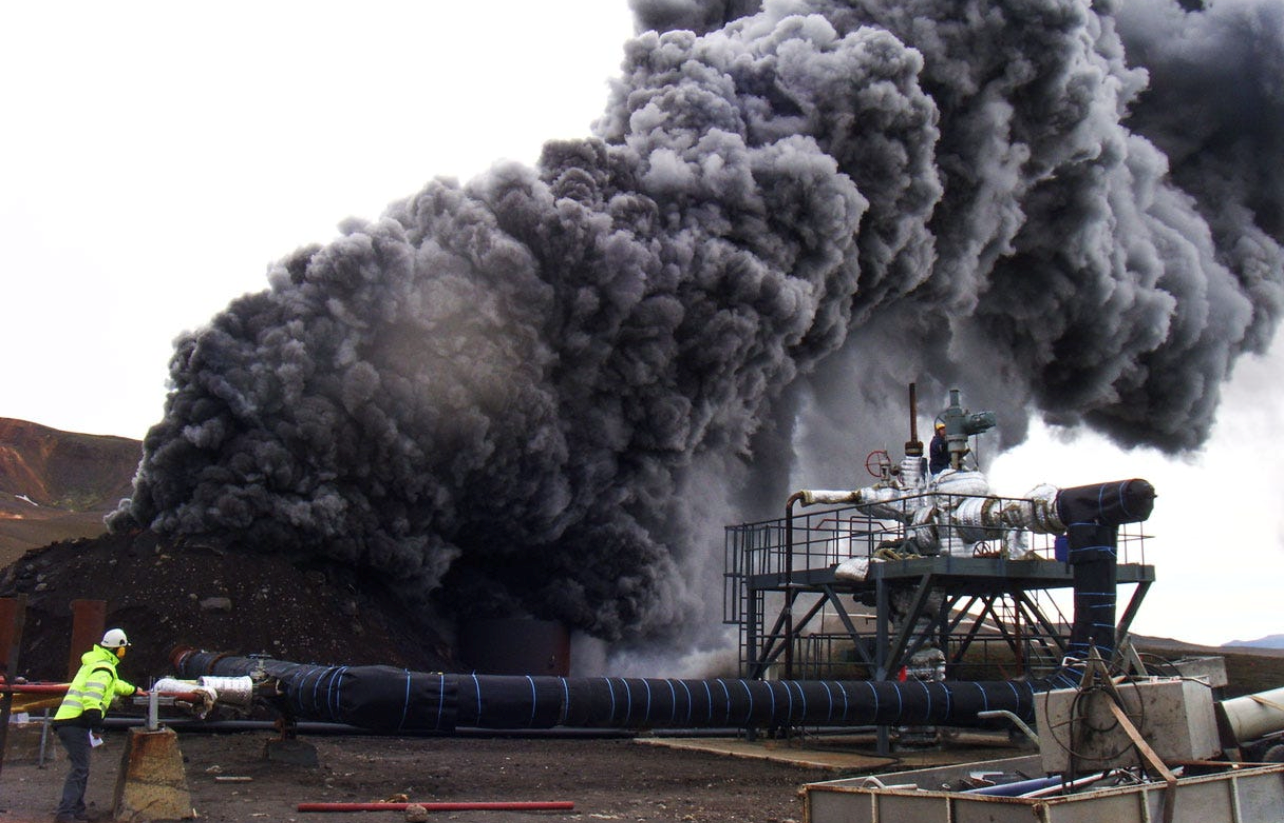 Dark-colored plume above geothermal drilling rig. 