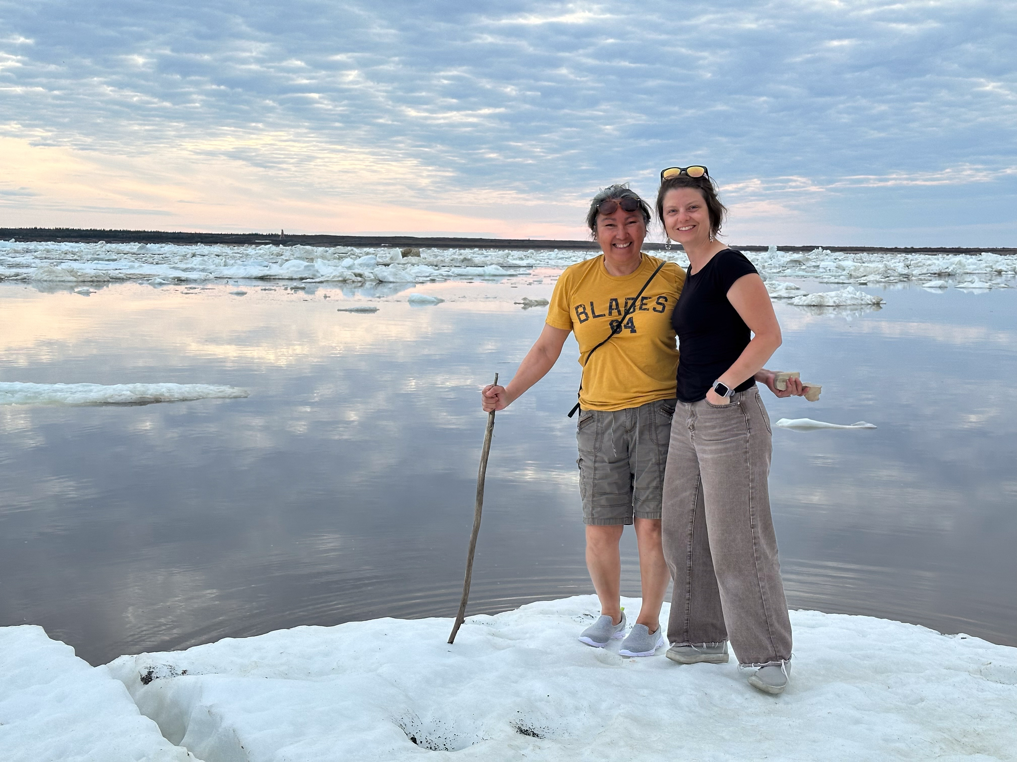 Coresearchers Georgina Berg and Katharina (Kt) Miller take a break from work to marvel at  ice breaking up on the Churchill River.