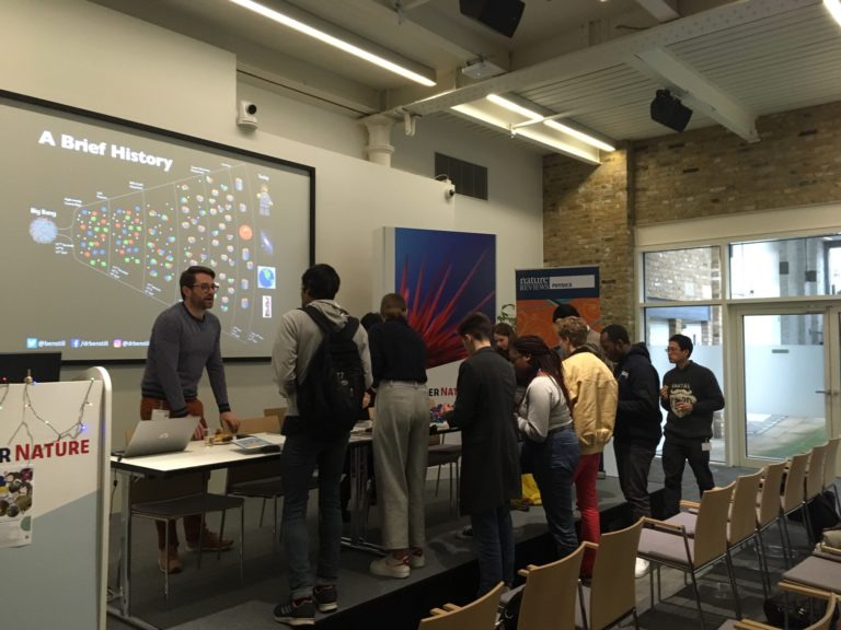 A group of participants around a table, building their own 'particles'