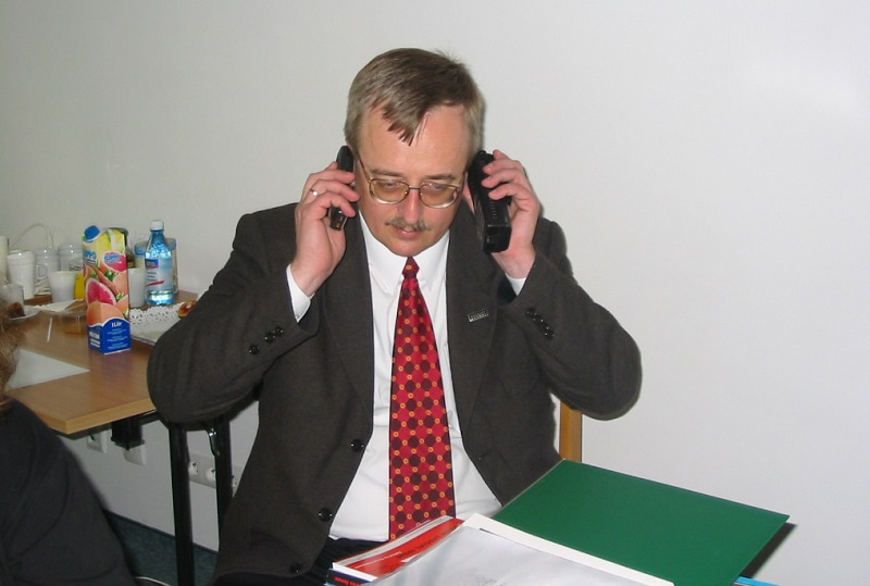 Photo of congress secretary Adam Szewczyk speaking on two phones at the same time.
