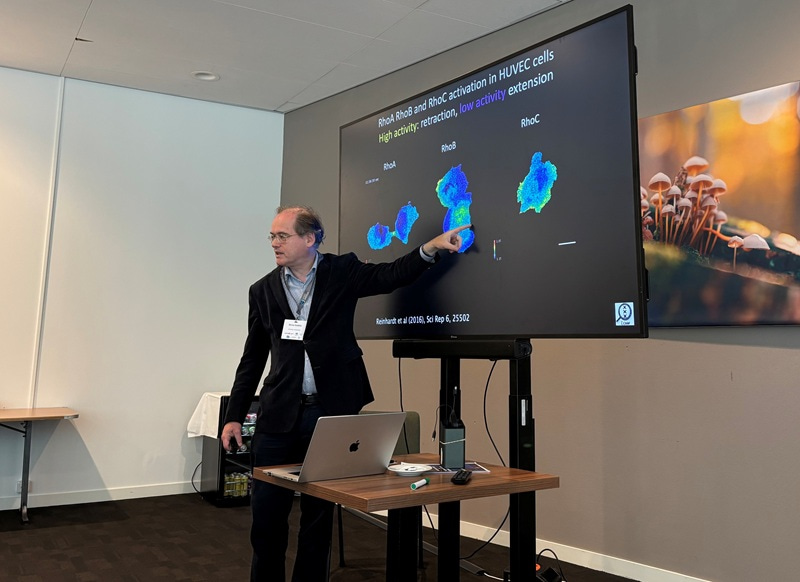Dorus Gadella standing in front of a monitor screen, pointing at the screen.