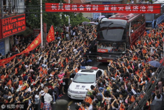 Parents cheering students who are on their way to sit gaokao