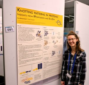 Eva  Klimentová standing by her event poster.