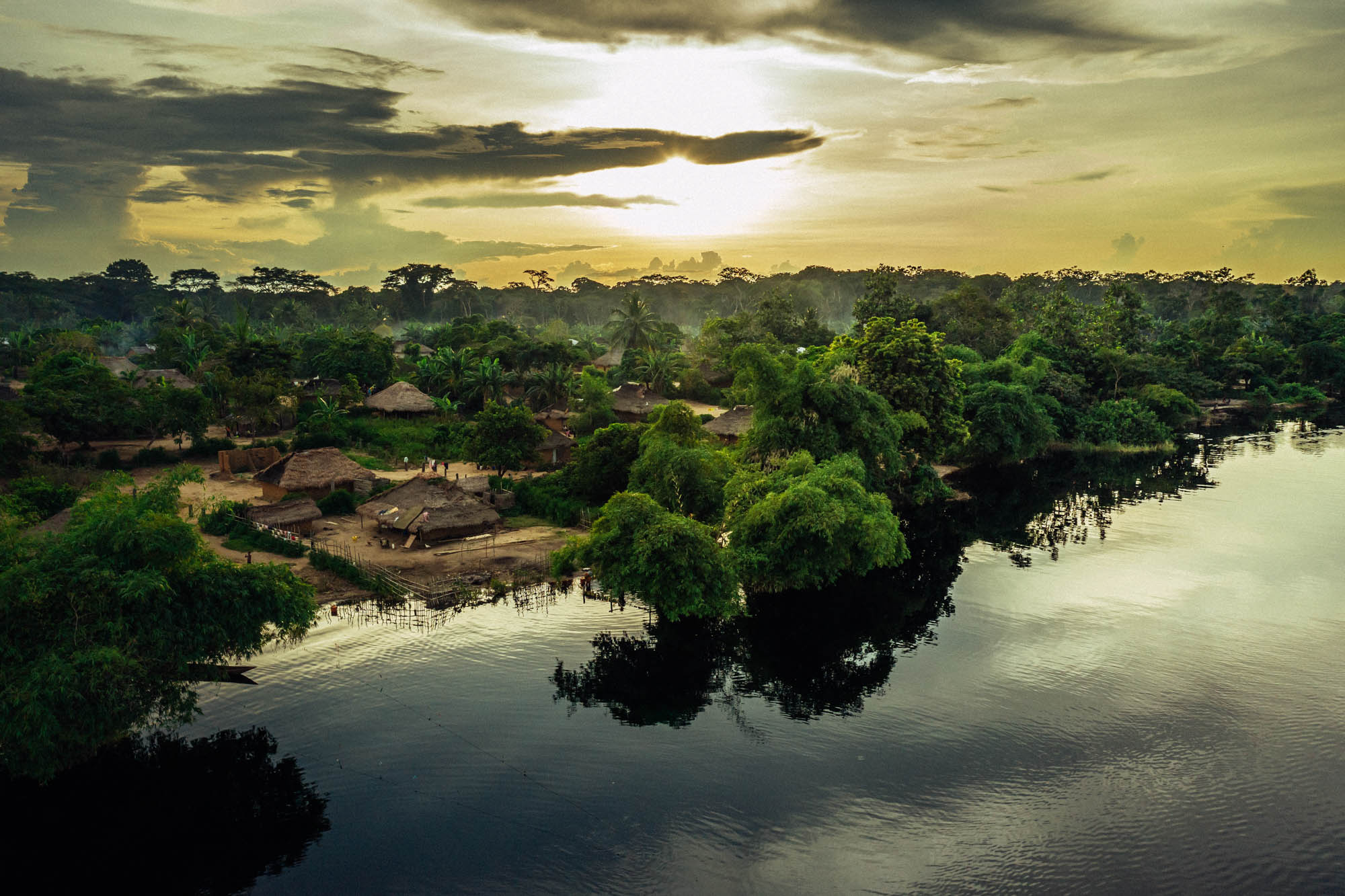 A village in a forest on the shores of a lake. 