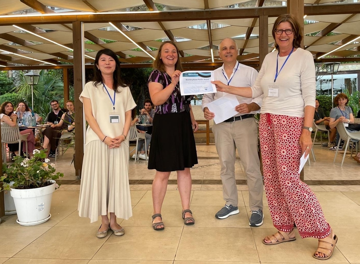 Award certificate presented to a young woman by other three people.