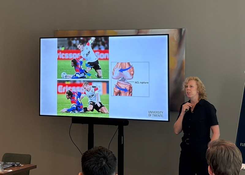 Janine Post standing by screen monitor.