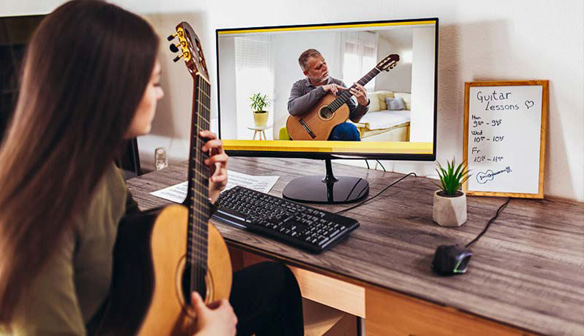 Student getting virtual guitar lessons | AVIXA Student getting virtual guitar lessons | AVIXA