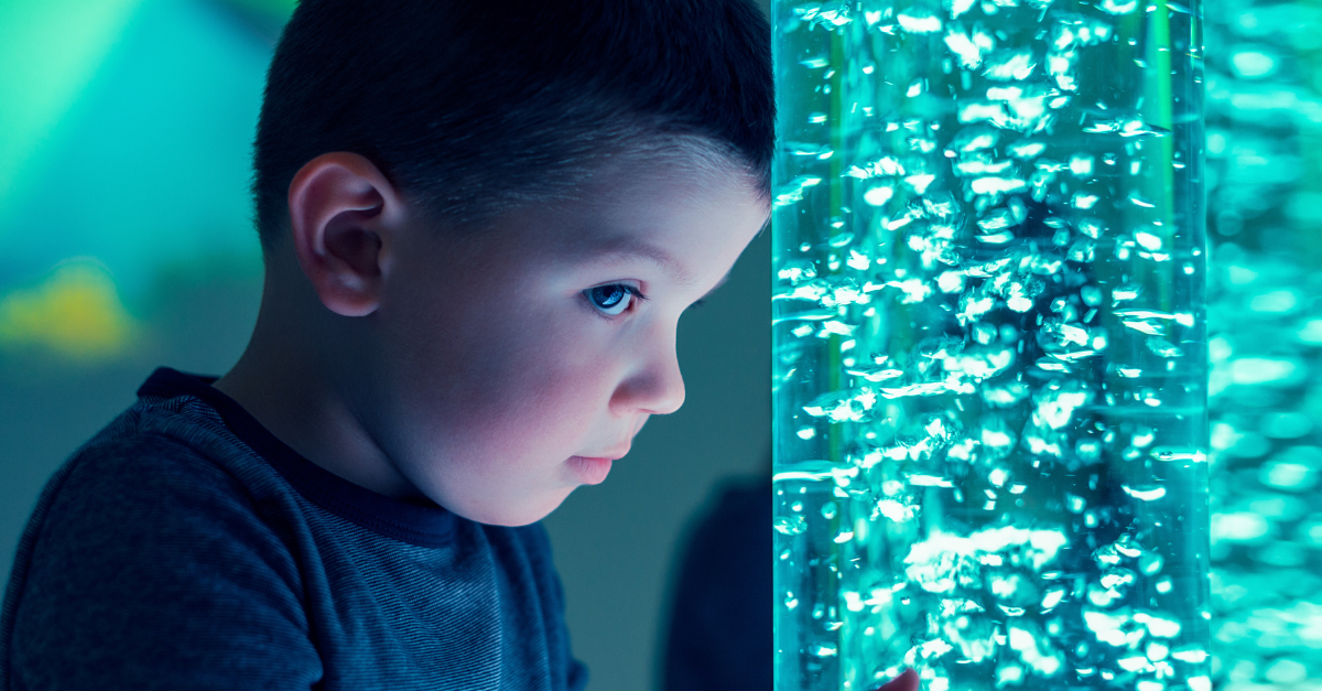 A young boy looking into a tube full of bubbles