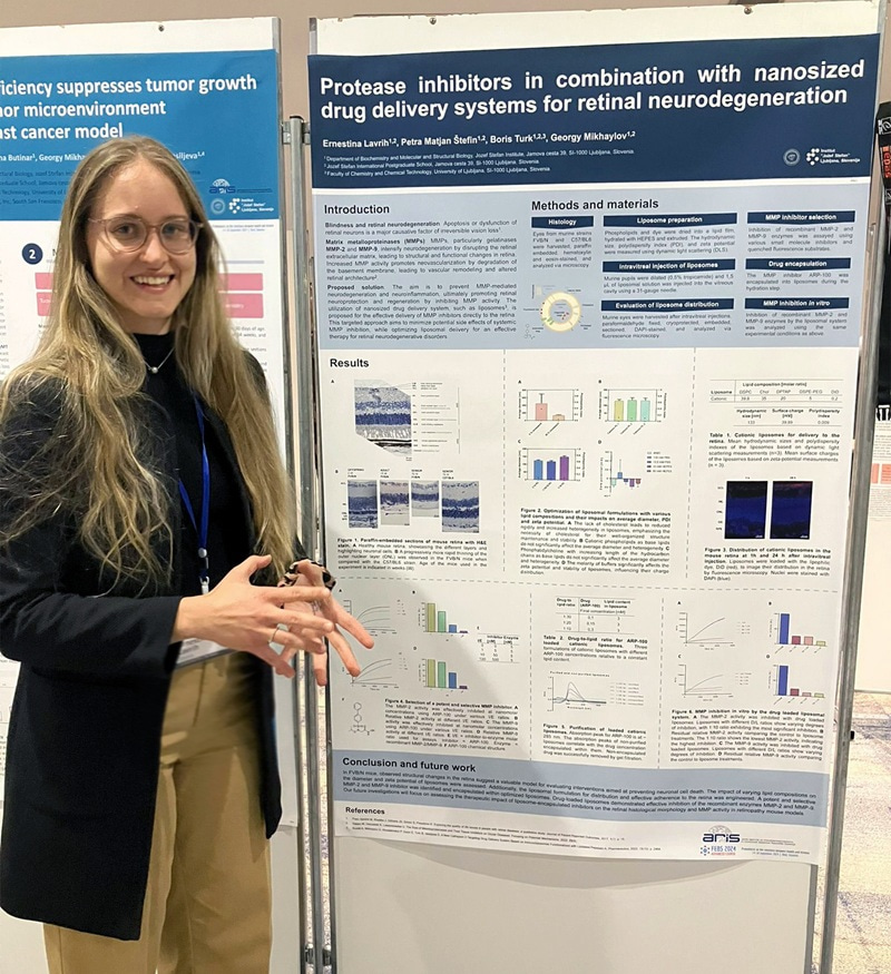Ernestina Lavrih smiling at the camera while standing next to a scientific poster.