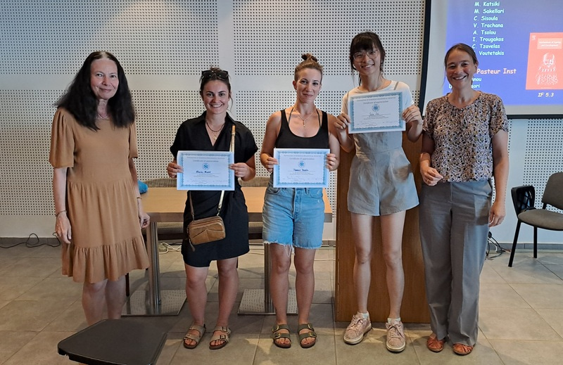 Photo of five women, three of them in the middle holding a certificate.