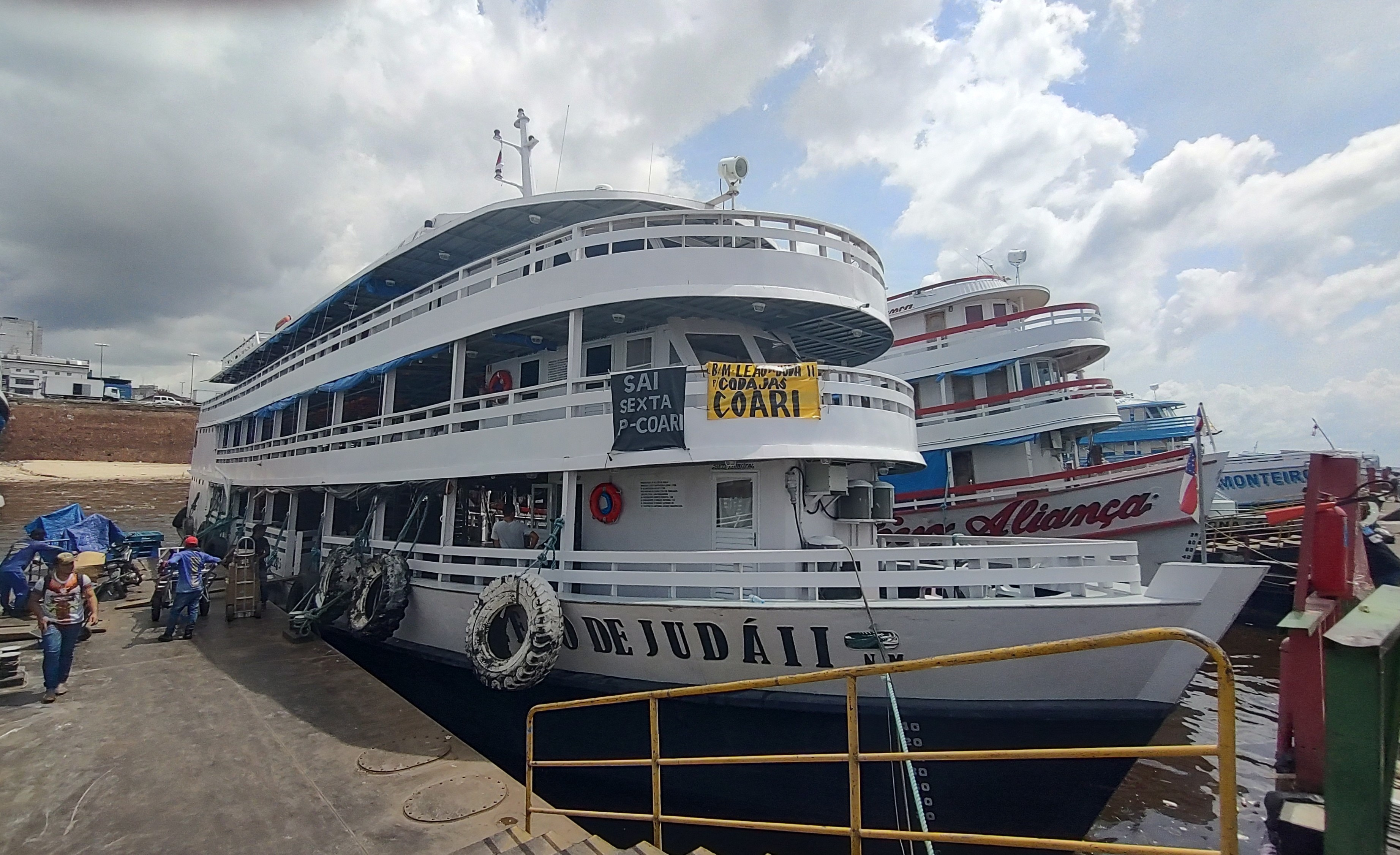 Regional boats docked at the Manaus River port and passengers waiting for their departure.