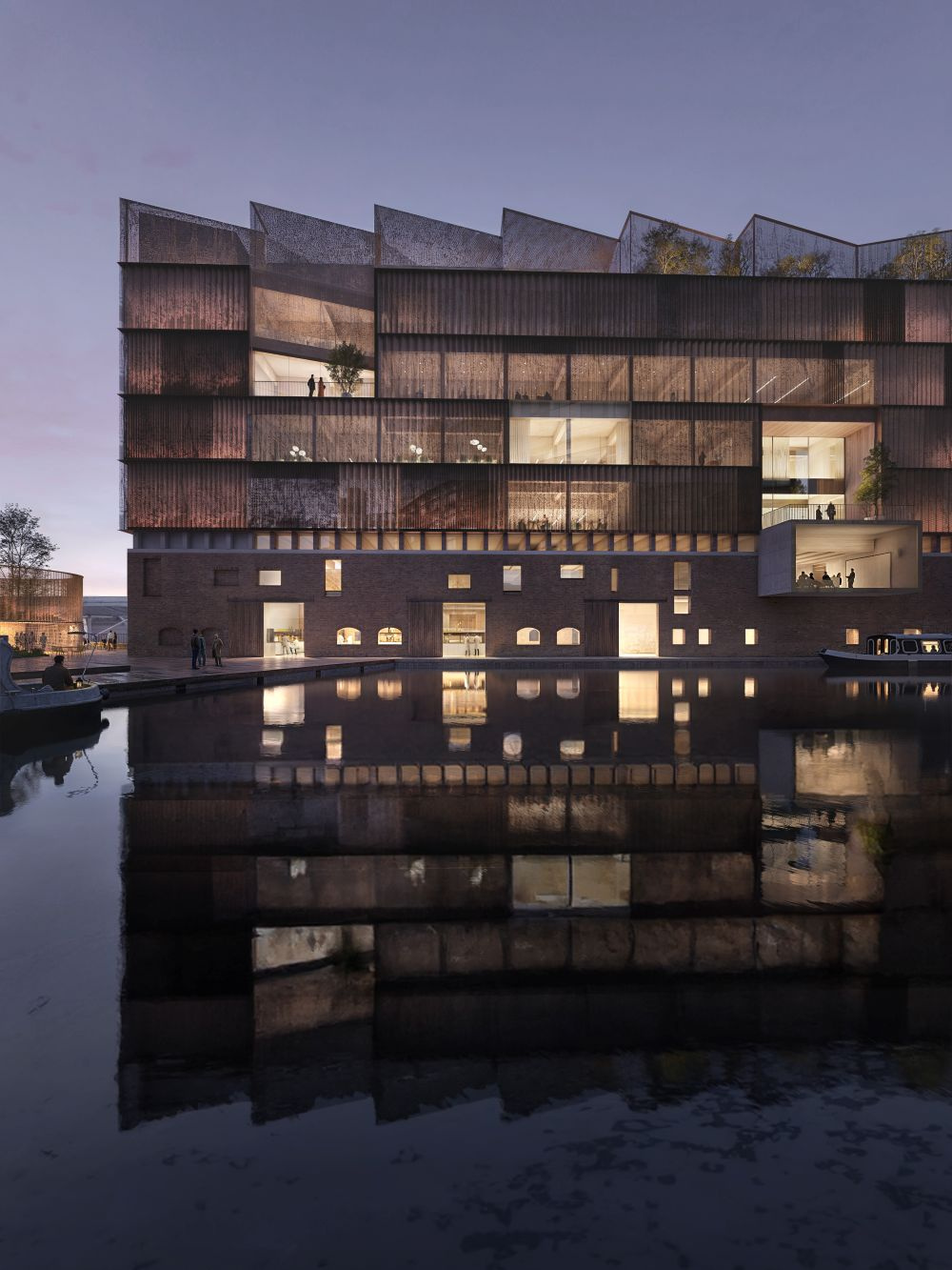 A striking six story building beside a calm body of water at twilight, featuring a lower brick section with irregularly arranged square and rectangular windows, and an upper portion covered in a perforated metal facade and angular roof lines. 