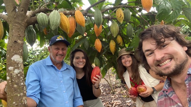 Picture of lead author with translator and interview participants in front of cacao tree.