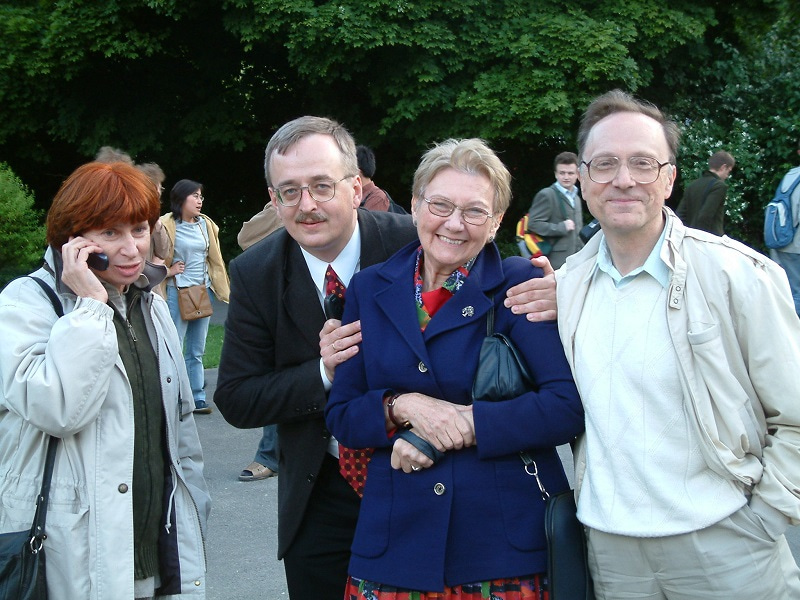 Group photo showing four congress participants, three smiling at the camera and one talking on a mobile phone.