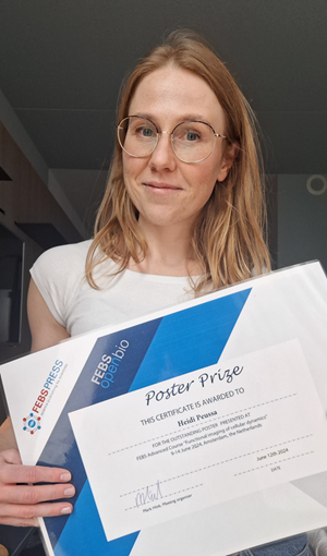 Photo of Heidi Peussa holding an award certificate.