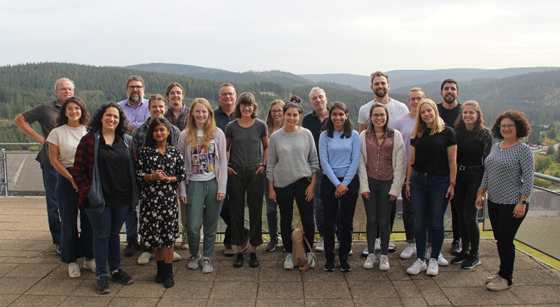 Photo of a large group, standing outside.