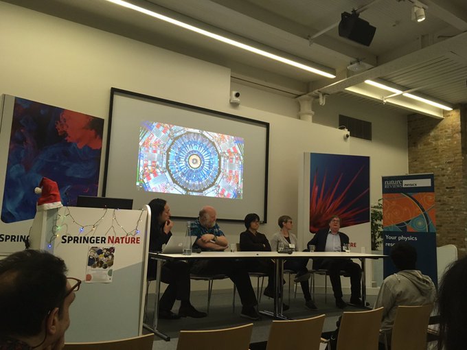 five Panelists sit behind a desk, answering questions from the audience