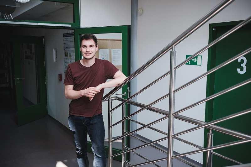 Portrait of Martin Toul, facing the camera, at the bottom of a staircase. Photo by Martin Indruch