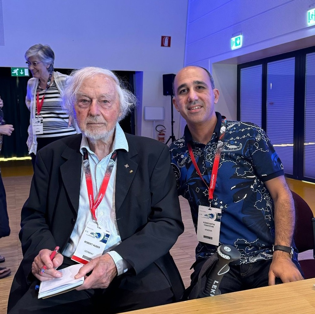 Photo of two men sitting side by side.