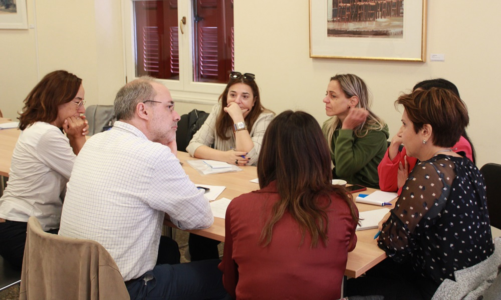 Photo of seven people sitting around a table.